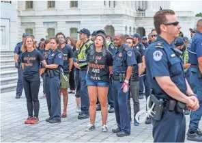  ??  ?? Police detain protesters who occupied the East Front steps of the U.S. Capitol before the Senate’s vote on Saturday.