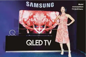  ??  ?? Model menunjukka­n TV QLED baru.