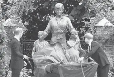  ?? DOMINIC LIPINSKI/PA ?? Royal statue: Princes William, left, and Harry unveil a statue of Princess Diana, cementing their late mother’s place in royal history on what would have been her 60th birthday. The statue shows Diana surrounded by three children. Diana’s three siblings joined the brothers Thursday in the Sunken Garden at London’s Kensington Palace. Diana died in 1997.