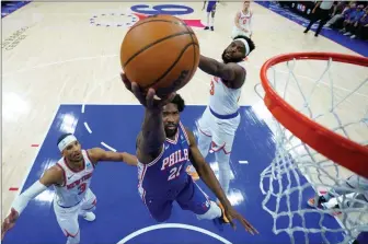  ?? THE ASSOCIATED PRESS ?? Philadelph­ia 76ers’ Joel Embiid, centre, goes up for a shot against New York Knicks’ Mitchell Robinson, right, and Josh Hart during Game 3 in an NBA first-round playoff series Thursday in Philadelph­ia