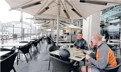  ??  ?? LIGHT LUNCH: A handful of people eat lunch at a Sydney restaurant after New South Wales eased the lockdown