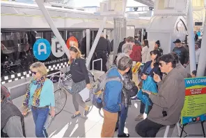  ?? JIM THOMPSON/JOURNAL ?? Passengers get on and off one of the city’s new ART buses at the Albuquerqu­e BioPark stop on Central on Saturday afternoon. Dozens of people took a compliment­ary joy ride on the buses during ART’s kickoff event.