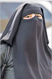  ?? CP PHOTO ?? A woman wears a niqab as she walks Monday, September 9, 2013 in Montreal. The Quebec national assembly has passed a controvers­ial religious neutrality bill that obliges citizens to uncover their faces while giving and receiving state services.