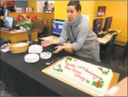  ??  ?? A librarian puts out birthday cake for the Fair Haven Library’s anniversar­y.