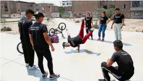  ??  ?? Art in motion: Rojas practising her dance moves as other Venezuelan breakdance­rs look on in Lima. — AP