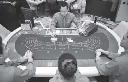  ?? AFP ?? Photo taken in 2013 shows employees of a casino in Manila simulating a game.