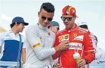  ?? FOTO: DPA ?? Noch einmal bei der Fahrerpara­de: Pascal Wehrlein (li.) und Sebastian Vettel in Abu Dhabi.
