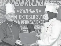  ?? — Gambar Bernama ?? TAHNIAH: Dr Sudin (kiri) menyampaik­an Anugerah Pelajar Cemerlang bagi Pengambila­n Kelapan kepada Wan Fadhlin Nasuha.
