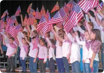  ??  ?? Students wave their flags during Richboro Elementary School’s morning assembly.