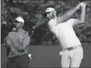  ?? ASSOCIATED PRESS ?? DUSTIN JOHNSON hits off the fourth tee as Tiger Woods looks on during a practice round for the U.S. Open Golf Championsh­ip on Tuesday in Southampto­n, N.Y.