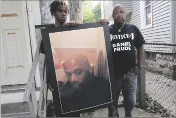  ?? ASSOCIATED PRESS ?? IN THIS SEPT. 3, 2020, FILE PHOTO, Joe Prude, brother of Daniel Prude, right, and his son Armin, stand with a picture of Daniel Prude in Rochester, N.Y.