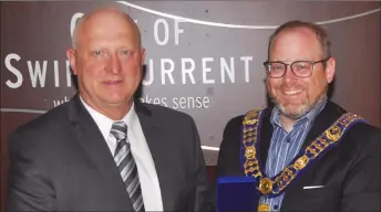  ?? Photo by Matthew Liebenberg ?? Mitch Minken (at left) receives the Sovereign’s Medal for Volunteers from Swift Current Mayor Denis Perrault, June 3.