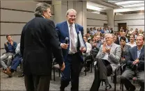  ?? GREG LOVETT / THE PALM BEACH POST ?? Cox Media executive Brian Cooper (left) hands the microphone Wednesday to Kirk Davis, CEO for GateHouse Media, to speak to Palm Beach Post and Daily News employees about GateHouse’s plan to buy the papers for $49.25 million.