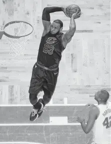  ?? Charles Krupa / Associated Press ?? Cavaliers star LeBron James soars for a dunk over the Celtics’ Al Horford, scoring two of his game-high 35 points in Sunday night’s Game 7 of the Eastern Conference finals in Boston.