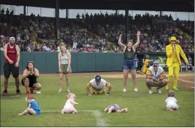  ?? STEPHEN B. MORTON/THE ASSOCIATED PRESS ?? Four infants and their parents take part in what the Savannah Bananas call The Slowest Race at the team’s game against the Wilmington Sharks on Saturday, June 11, in Savannah, Ga.