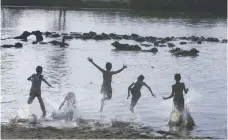  ?? — AFP ?? Iraqi boys swim in the Euphrates river in Najaf, on Wednesday.