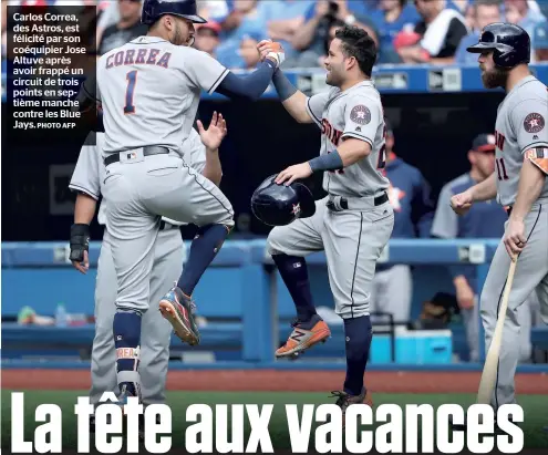  ?? PHOTO AFP ?? Carlos Correa, des Astros, est félicité par son coéquipier Jose Altuve après avoir frappé un circuit de trois points en septième manche contre les Blue Jays.