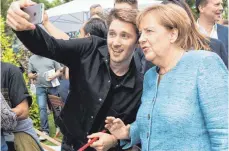  ?? FOTO: DPA ?? Selfie mit der Kanzlerin: Der Tag der offenen Tür war für Angela Merkel der letzte Termin vor der Rückkehr zum Tagesgesch­äft.