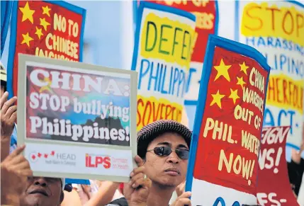  ?? AP ?? Filipino protesters hold placards with slogans during a rally outside the Chinese consulate in Manila last April. Territoria­l disputes in the South China Sea remain major security threats in the region as Malaysia assumes the Asean chairmansh­ip this...