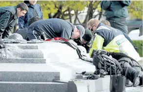  ?? THE CANADIAN PRESS FILES ?? A soldier, police and paramedics tend to a soldier shot at the National War Memorial in Ottawa on Oct. 22, 2014.