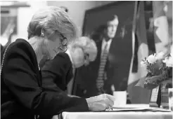  ?? Colleen De Neve/calgary Herald ?? Members of the public and invited guests signed the book of condolence­s before the memorial.