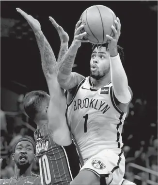  ?? John Raoux Associated Press ?? NETS GUARD D’Angelo Russell ( 1), going up for a shot against Magic swingman Evan Fournier, will return to Staples Center tonight to face his former Lakers teammates for the f irst time.