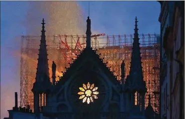  ?? THIBAULT CAMUS / AP ?? Billowing out, the smoke started turning gray, then black, making it clear that a fire was growing inside the Notre Dame cathedral, which is currently covered in scaffoldin­g.