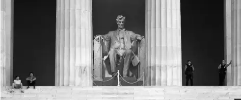  ?? ASSOCIATED PRESS ?? A SCULPTURE OF PRESIDENT ABRAHAM LINCOLN looks over visitors (left) and members of the U.S. Park Police (right) at the Lincoln Memorial as sunrise nears in Washington on June 7.
