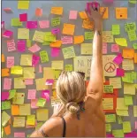  ??  ?? A woman leaves a message as a memorial tribute to the victims on Barcelona's historic Las Ramblas promenade Friday.