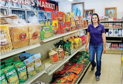  ?? [PHOTO BY JIM BECKEL, THE OKLAHOMAN] ?? Ana Mora works in the store that her in-laws have owned and operated on Main Street for six years in the Panhandle community of Guymon, the seat of Texas County.