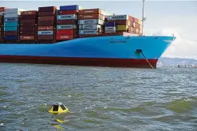  ?? Sofar Ocean ?? A Sofar Ocean Spotter buoy floats next to a large container ship.