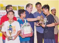  ??  ?? JUHARI menyampaik­an hadiah kepada pemenang kejohanan futsal remaja.