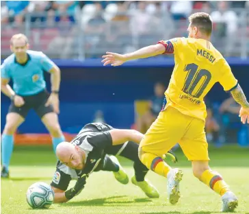  ??  ?? Barcelona’s Argentinia­n forward Lionel Messi (right) challenges Eibar’s Portuguese Serbian goalkeeper Marko Dmitrovic during the Spanish league football match at the Ipurua Stadium in Eibar.