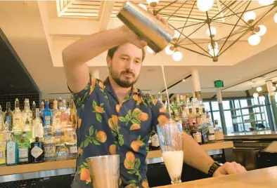  ?? AMY DAVIS/BALTIMORE SUN PHOTOS ?? Bartender Christian Parent mixes a spirit-free drink called “Dorothy in the Daytime” at Topside, a restaurant bar on the top floor of Hotel Revival in Mount Vernon.