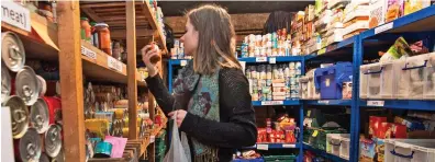  ??  ?? Helping hand: A volunteer at a London food bank. Usage is up 52 per cent in some areas