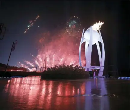  ?? THE ASSOCIATED PRESS ?? Fireworks explode behind the Olympic flame during the opening ceremony of the 2018Winter Olympics in Pyeongchan­g, South Korea, Friday, Feb. 9, 2018.