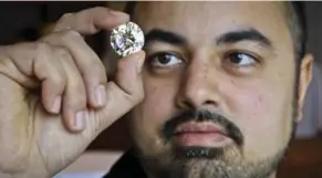  ?? DAVE COOPER/TORONTO STAR FILE PHOTO ?? Ritchies Auctioneer­s, managing director Kashif Khan, seen examining a rare diamond in 2011, co-founded BuzzPR with Global news anchor Leslie Roberts after Roberts improved a news release for him.