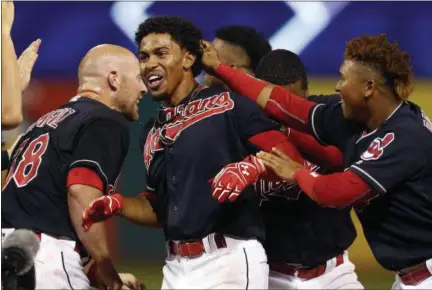  ?? RON SCHWANE — THE ASSOCIATED PRESS ?? The Indians’ Francisco Lindor, center, is mobbed by teammates after driving in the winning run off Nationals pitcher Oliver Perez during the ninth inning.