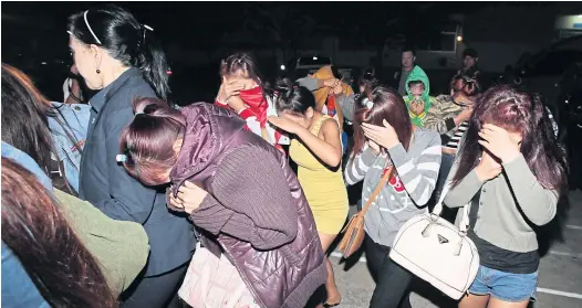  ?? APICHIT JINAKUL ?? Women, including Lao nationals, cover their faces as they are rescued from restaurant­s where they were lured into selling sex in Suphan Buri yesterday. Police and welfare workers said 72 females aged between 14-20 who were duped into working as...