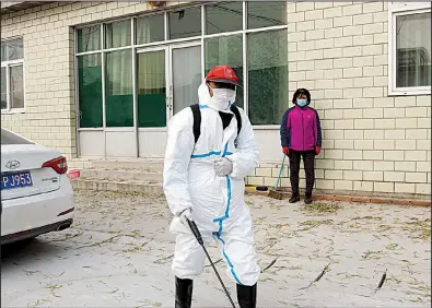 ?? AP/NG HAN GUAN ?? A worker sprays disinfecta­nt near a sealed-off pig farm last month on the outskirts of Beijing as an African swine flu outbreak continues to curtail pork production in China.