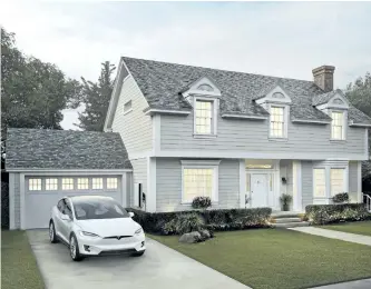  ?? THE ASSOCIATED PRESS ?? A house is seen with Tesla’s new slate solar roof tiles. Tesla Inc. has started production of the cells for its solar roof tiles at its factory in Buffalo, N.Y.