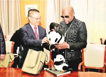  ?? — AFP photo ?? This picture taken on November 30, 2017 shows US boxer Floyd Mayweather (R) receiving a stuffed panda toy during an adoption ceremony after he adopted a panda baby at the Chengdu Research Base of Giant Panda Breeding in Chengdu in China's southweste­rn...