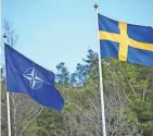  ?? FREDRIK SANDBERG/TT NEWS AGENCY/AFP ?? The NATO flag, left, is raised next to a Swedish flag at a ceremony in Stockholm on Monday.