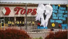  ?? ?? Investigat­ors stand outside during a moment of silence for the victims of the Buffalo supermarke­t shooting outside the Tops Friendly Market on Saturday in Buffalo, N.Y. Tops was encouragin­g people to join in a moment of silence Saturday.