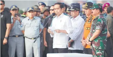  ?? — AFP photo ?? Indonesia’s President Joko Widodo (centre) delivers a statement on the search and rescue efforts for the ill-fated Lion Air flight JT 610 at Jakarta port, accompanie­d by Transporta­tion Minister Budi Karya Sumadi (third right), head of search and rescue board Muhammad Syaugi (second right) and military chief Marshall Hadi Tjahjanto (right).