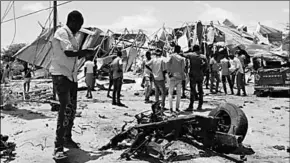  ??  ?? Somalis inspect the damage caused at the scene of an attack on an Italian military convoy in Mogadishu. (Photo:Al Jazeera)