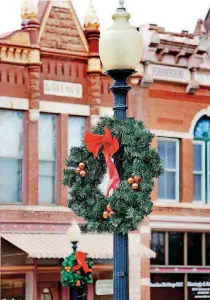  ??  ?? Decoration­s brighten shops and buildings in downtown Guthrie for Territoria­l Christmas festivitie­s, including the Historic Homes Tour, which officials say will go on as planned even if weather is bad.