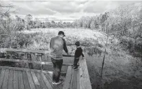 ?? Mark Mulligan / Staff file photo ?? Camden Smith and his father, Chris, check out the Pine Brook South Wetlands park in Clear Lake in 2020.