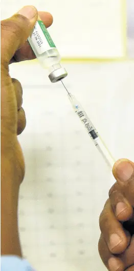  ?? KENYON HEMANS/ PHOTOGRAPH­ER ?? A nurse preparing to administer a shot of the COVID-19 vaccine at the Windward Road Health Centre in Kingston on Monday.