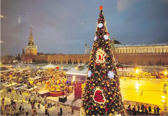  ??  ?? A Christmas tree with the Christmas market, left, the ice rink on Red Square, bottom right, and the Spasskaya Tower, left, in Moscow, Russia.